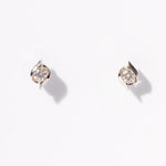 Pair of diamond stud earrings on a light gray background