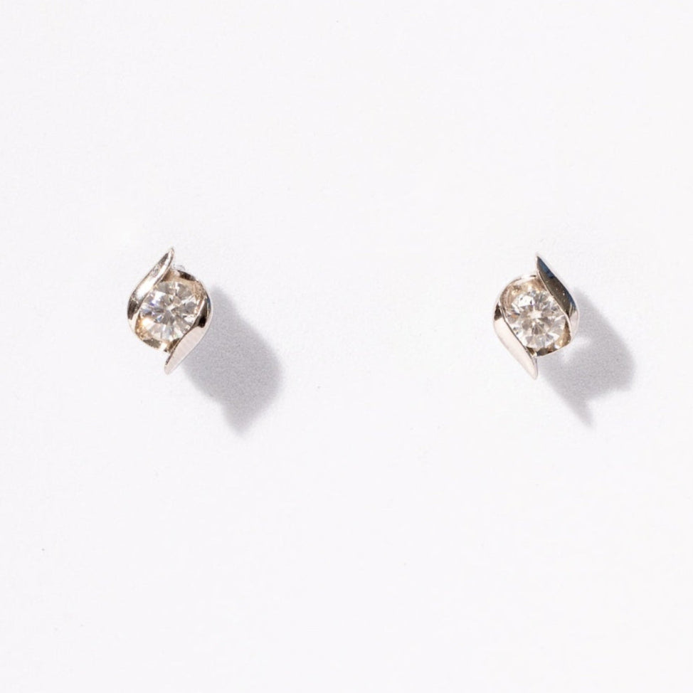 Pair of diamond stud earrings on a light gray background